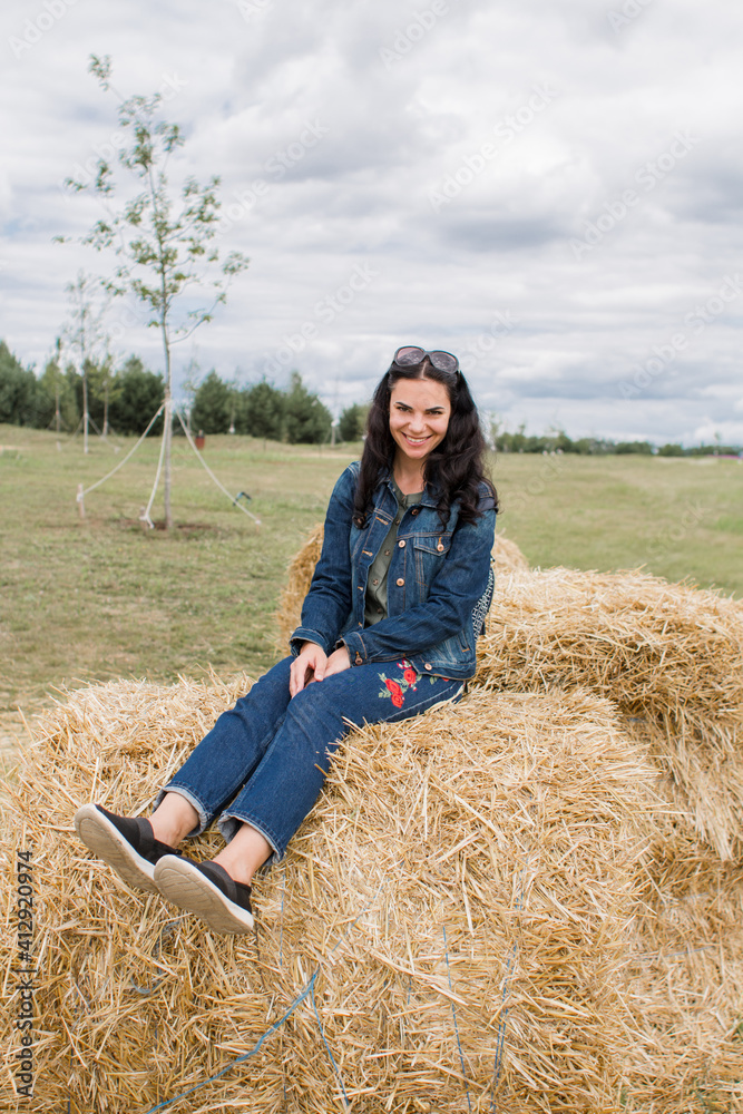 girl on sheaves of hay in summer with dark hair beautiful girl on sheaves of hay in summer with dark hair beautiful