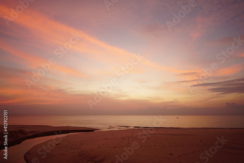 Nature image Landscape view of sunset over beach. Twilight sky red background. © BUDDEE