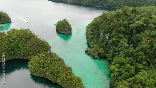 Triton Bay: Boat On Turquoise Sea And Green Tropical Trees In Kaimana Islands. Aerial View Of Wide Angle Nature; Pacific Ocean And Picturesque Landscape In Papua, Indonesia. photo