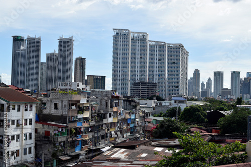 Story house tenement clusters foreground and tower buildings background in a busy city