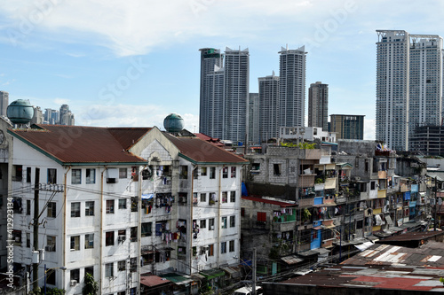 Story house tenement clusters foreground and tower buildings background in a busy city