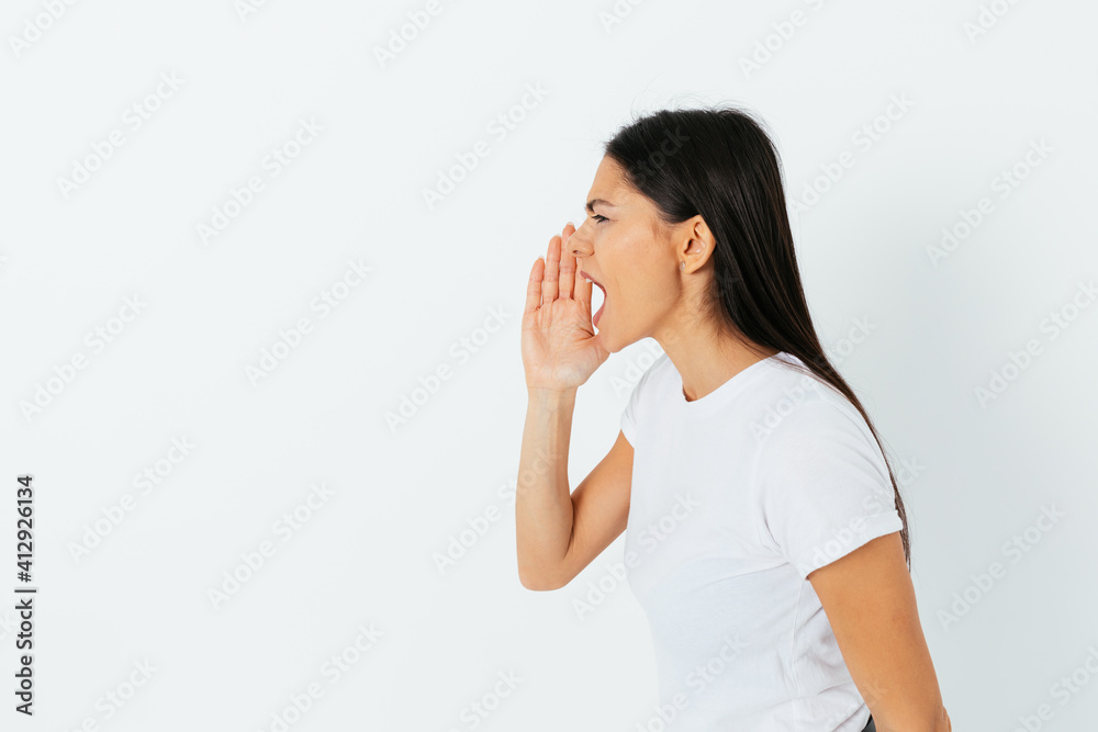 Side view studio portrait screaming young woman holding her hand Side view studio portrait screaming young woman holding her hand