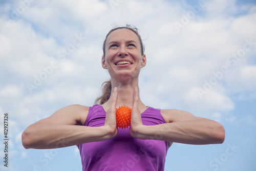 yoga hedgehog .orange bright massage ball girl athlete fitness exercise with a ball in the fresh air in the summer. Fitness Good mood, positive mood, happiness in motion © Александр Копелев