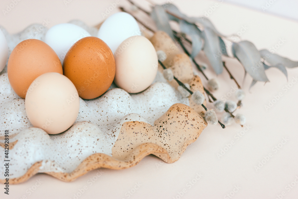 Easter unpainted chicken eggs in a ceramic egg holder. Dried flowers, beige color, place for text Easter unpainted chicken eggs in a ceramic egg holder. Dried flowers, beige color, place for text