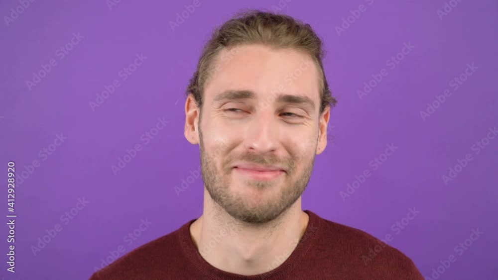 young aggressive long-haired guy showing blah blah gesture on isolated purple background. Sarcastic face. 4k young aggressive long-haired guy showing blah blah gesture on isolated purple background. Sarcastic face. 4k