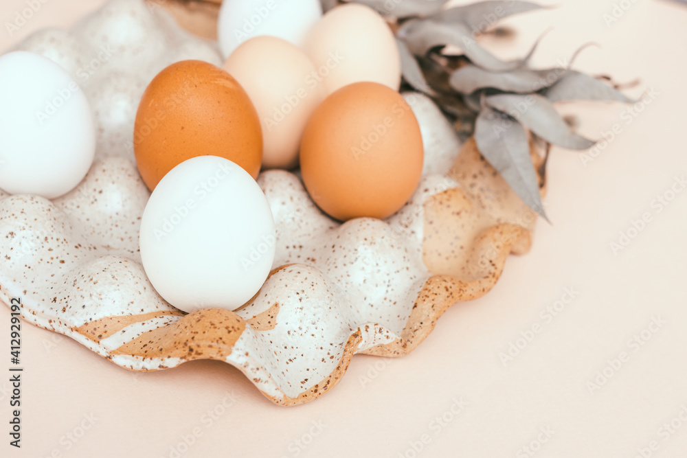 Easter unpainted chicken eggs in a ceramic egg holder. Dried flowers, beige color, place for text Easter unpainted chicken eggs in a ceramic egg holder. Dried flowers, beige color, place for text