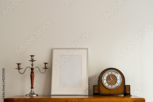 Still life of Oak Cupbaords and top with Silver Picture frame Mock up and antique  wooden and silver candle stick  and old mechanical wind up clock