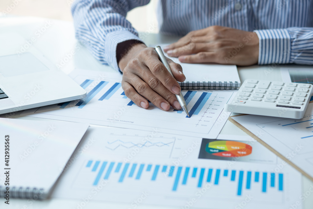 Financial Businessman analyzes calculator graph of the company's performance create profits and growth, Market research reports income statistics, calculator to calculate Financial Accounting concept. Financial Businessman analyzes calculator graph of the company's performance create profits and growth, Market research reports income statistics, calculator to calculate Financial Accounting concept.