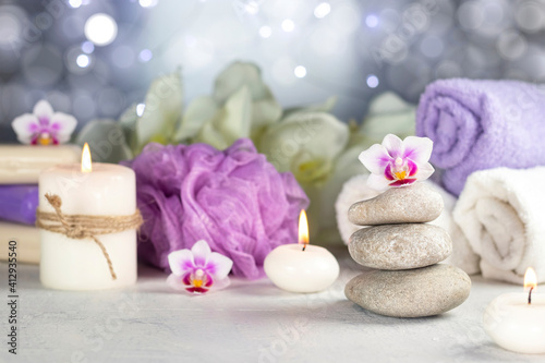 Stones  burning candles  towel  abstract lights. Spa resort therapy composition.