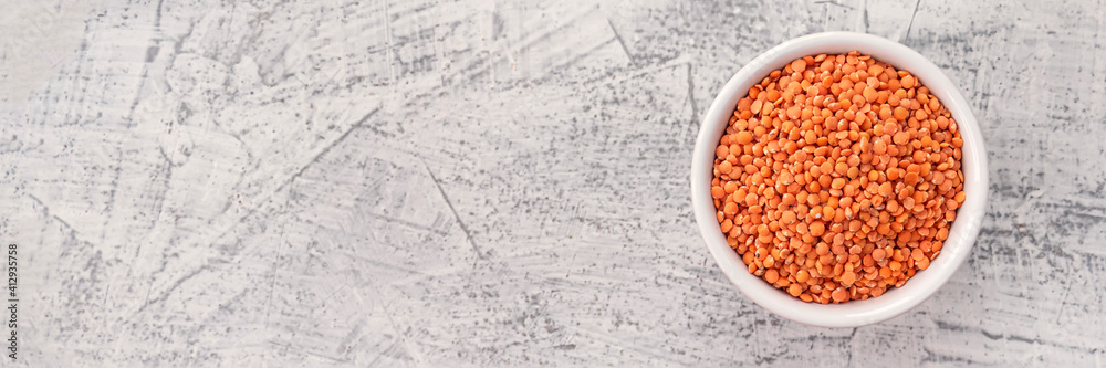 Red lentils in white plate on white stone background. Vegetarian super food. Red lentils in white plate on white stone background. Vegetarian super food.