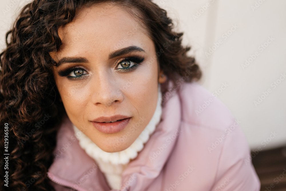 Close-up face female very beautiful expressive eyes with makeup figs and luxurious plump lips of a brunette with curly hair. High quality photo