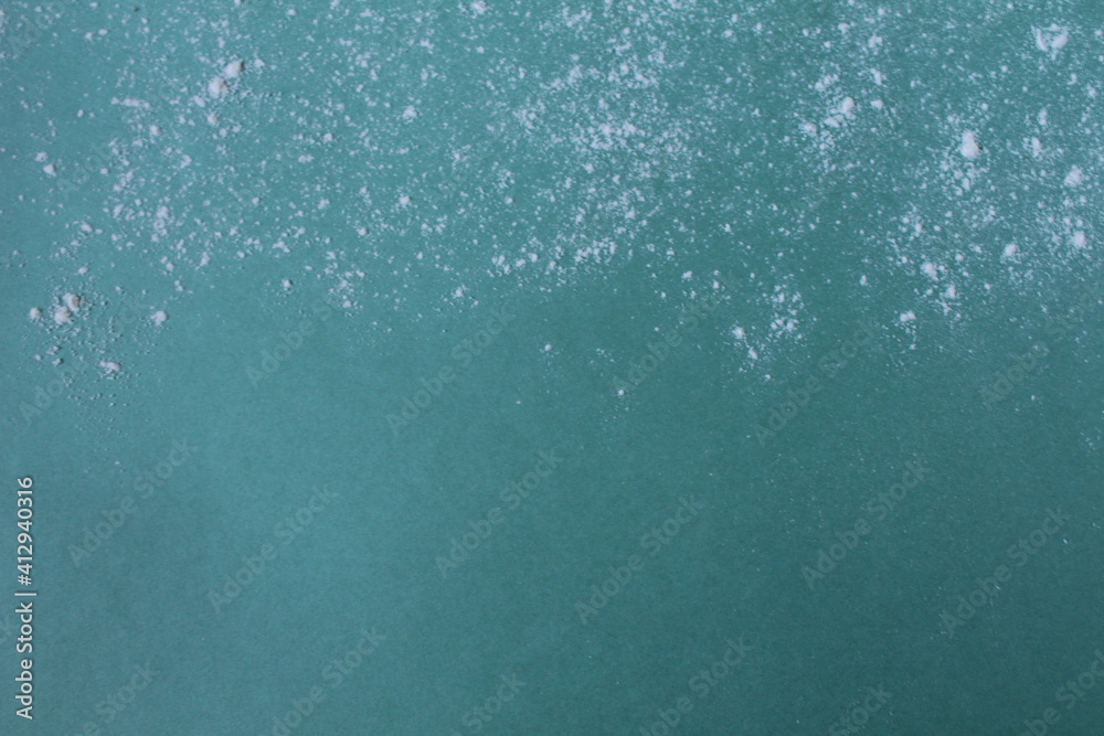 Background meal flour or powdered sugar scattered on a mint blue green background with a copypeist eat for text Background meal flour or powdered sugar scattered on a mint blue green background with a copypeist eat for text
