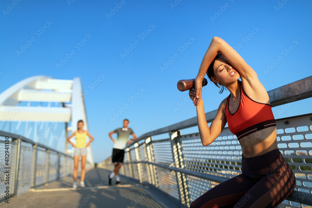 Portrait of athletic fit young woman resting after running outdoor