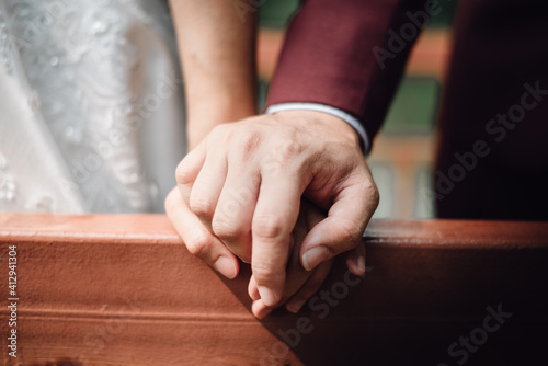 The bride and groom hold hands