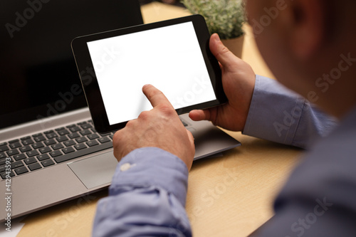 Hand holding tablet in office