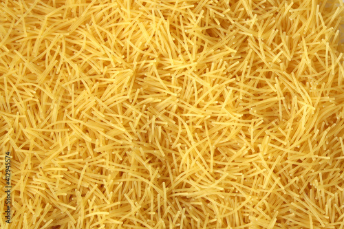 Dry uncooked vermicelli pasta as a background. photo