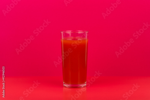 Wallpaper Mural Glass of tomato juice on red table against pink background with copy space. Concept of vegan food, detox, healthy eating and wellness Torontodigital.ca