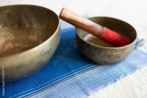Singing bowl or tibetan bowl and wooden mallet or stick for meditation, mindfulness, sound healing, relaxation. With a book.