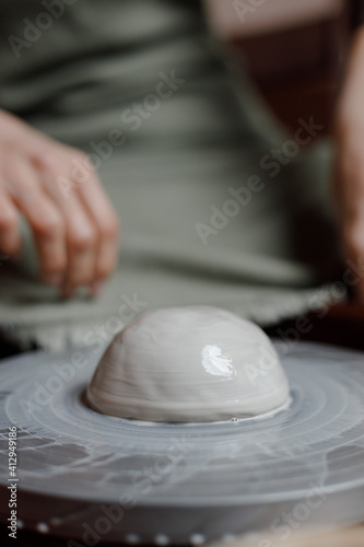 piece of grey eco-friendly clay on a potter's wheel. utensils of clay with their own hands. business in his workshop. people of art and needlework. creative process of authenticity