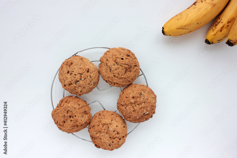 Oatmeal banana cookies on white table. Overhead view of oat biscuits and yellow fruits on white background with copy space Oatmeal banana cookies on white table. Overhead view of oat biscuits and yellow fruits on white background with copy space