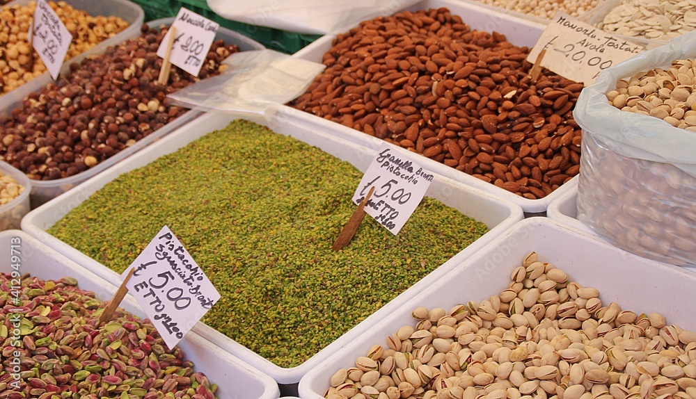 shelled pistachios, peeled pistachios and pieces of crushed pistachios, almonds and hazelnuts in the market, nut stall, Sicilian street market