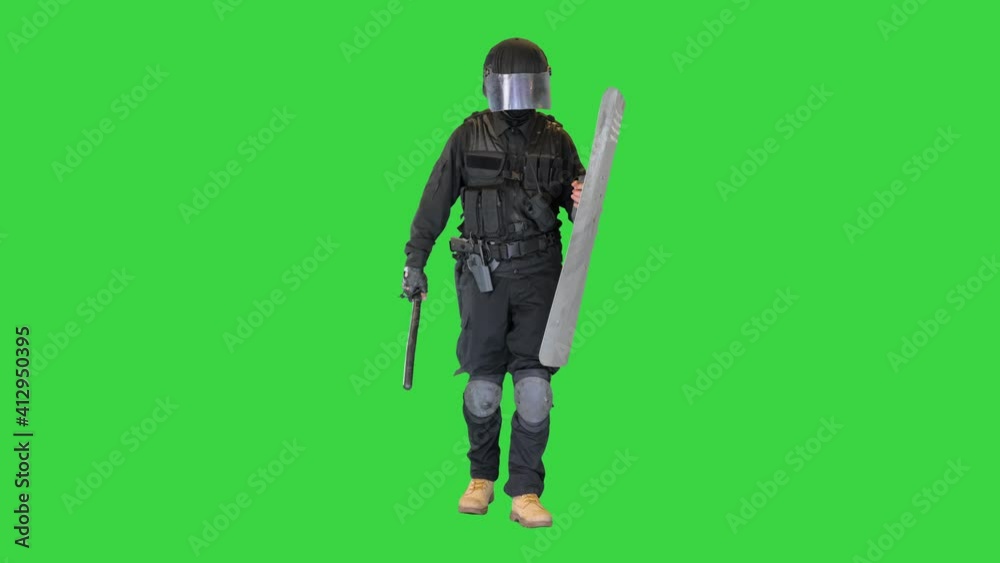 Heavily armored policeman with a shield and a baton walking on a Green Screen, Chroma Key. Heavily armored policeman with a shield and a baton walking on a Green Screen, Chroma Key.