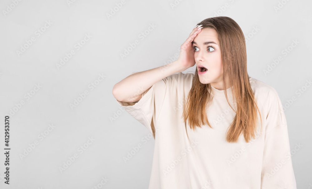 shocked woman holding her mouth wide open, looking away with a displeased expression, holding her head shocked woman holding her mouth wide open, looking away with a displeased expression, holding her head