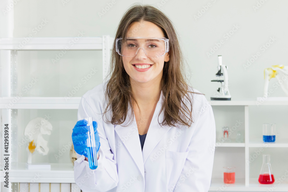 female scientist wear safety glasses and blue glove take chemicals into a test tube to study chemicals female scientist wear safety glasses and blue glove take chemicals into a test tube to study chemicals