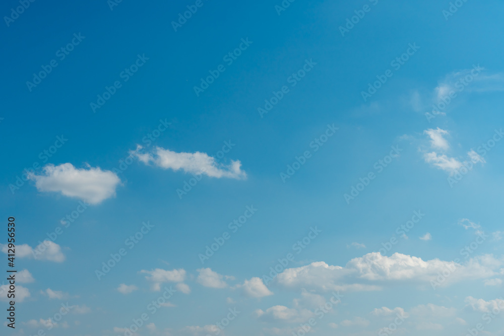 Beautiful fluffy clouds in the evening sky. The sunlight gives a side light on the clouds. Clouds before rain.