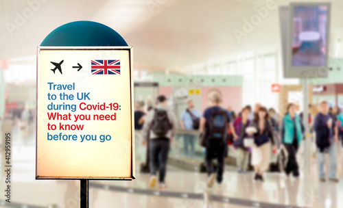 a signal inside an airport that warns about what to know before flying to England during the Covid-19 pandemic