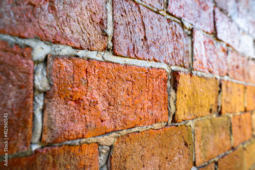 Red brick wall or clay stone wall with glaze coating surface during natural lighting reflect on it. Background and Texture of building photo.