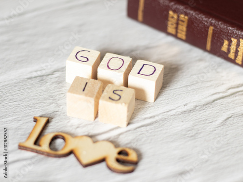 God is Love. Wooden text and Holy Bible with gold letters. God the Father and Jesus Christ love us all. Salvation, forgiveness,  redemption, faith, vindication scriptures verses passages of God’s Word photo