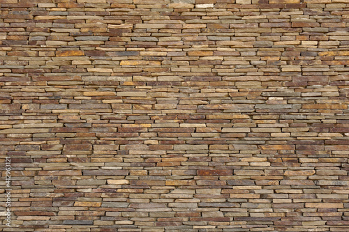 A wall of natural flat stones laid out horizontally. Texture for background.