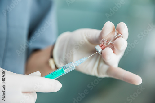 Foto Sanitaria con guantes introduciendo la vacuna en el vial
