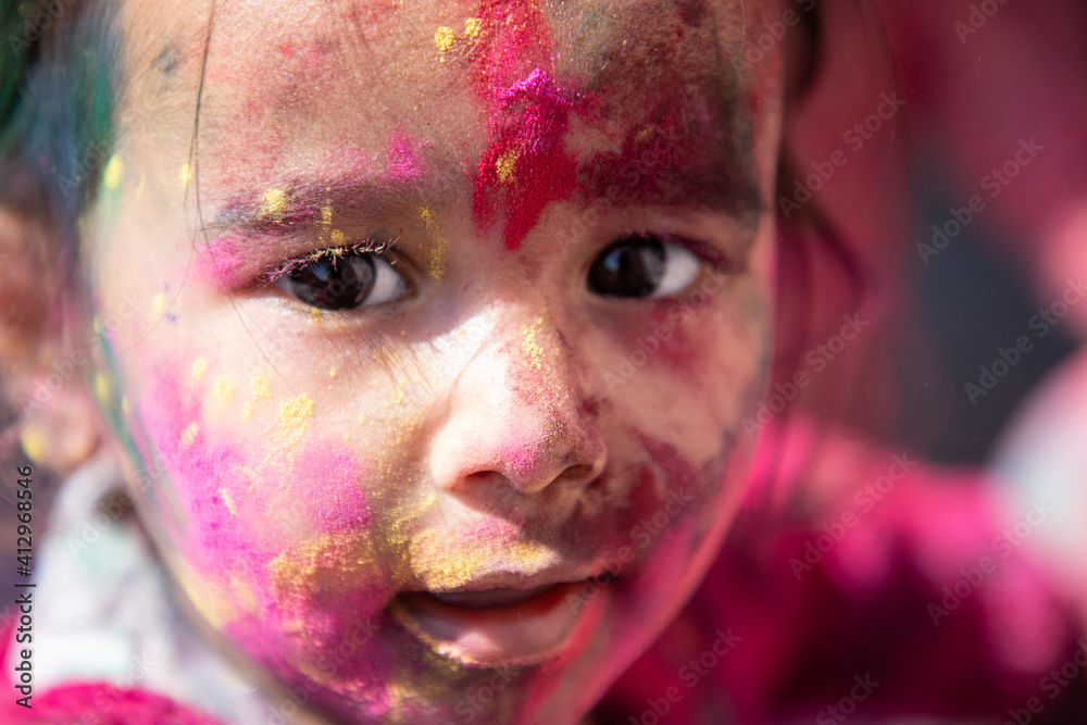 Closeup of Little Girl Face with full of Colors. Holi concept. Celebrating Holi Festival India