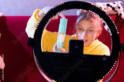 A beauty blogger shows the viewers cosmetics. The blogger advertises women's cosmetics to his followers on camera. photo