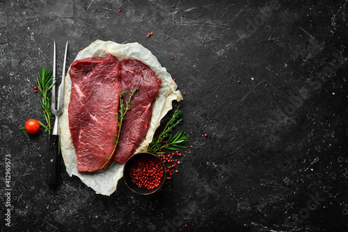 Fotografia Two raw veal steaks with rosemary and spices