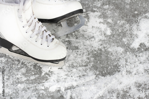 close-up of figure skates on an ice background. Ice skating outdoor activities with the family in winter