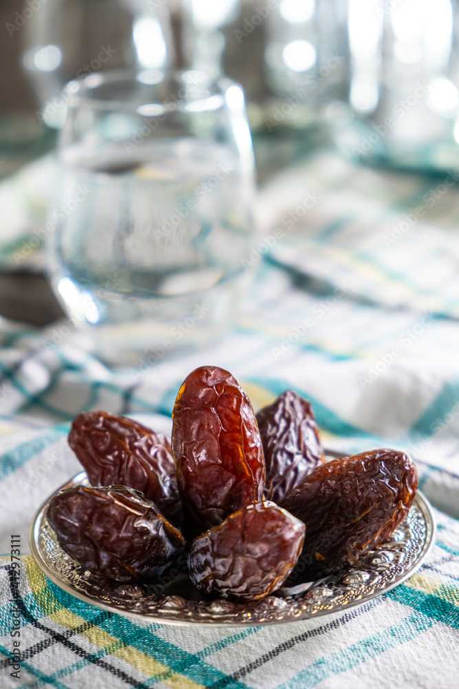 A Heap of Dates Fruit on Traditional Silver Plate. Iftar Appetizer for Muslim People. Usually Eating on Ramadan. Preparing for Iftar Time. Table Ready for Dinner. A Heap of Dates Fruit on Traditional Silver Plate. Iftar Appetizer for Muslim People. Usually Eating on Ramadan. Preparing for Iftar Time. Table Ready for Dinner.