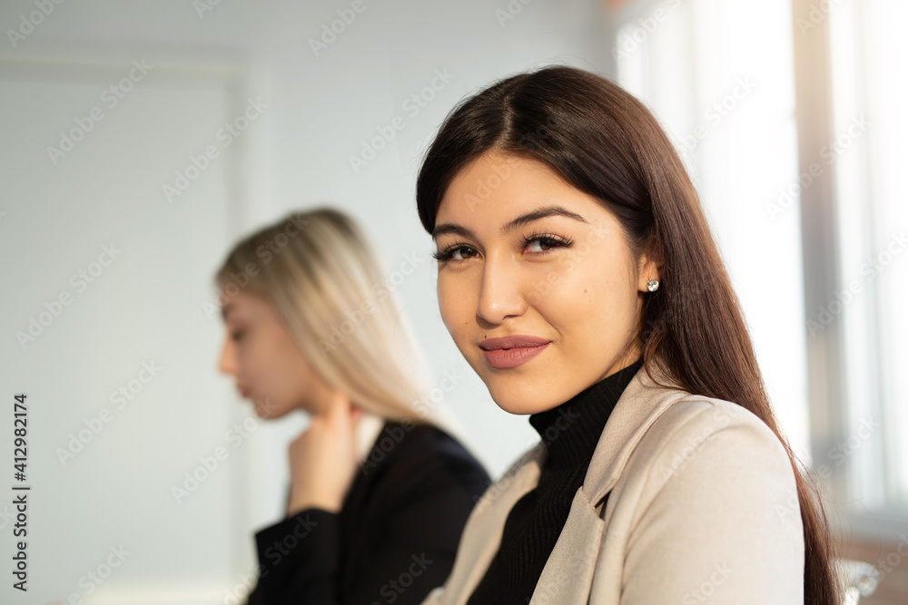 two beautiful young women at the table in the office two beautiful young women at the table in the office