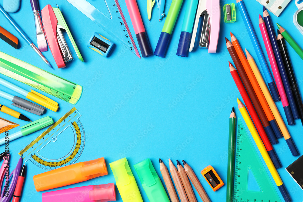 Fototapeta premium Frame of different stationery on light blue background, flat lay with space for text. Back to school