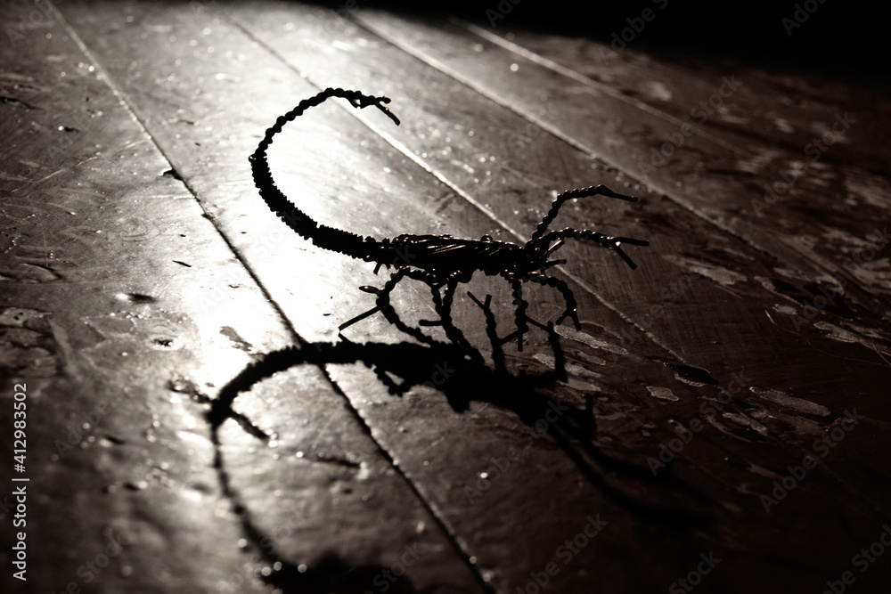 Metal scorpion on the wooden floor Metal scorpion on the wooden floor