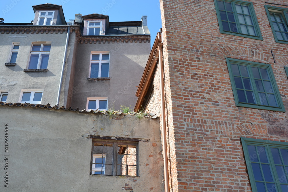 Facade of residential houses with brick and white windows in Danzig, Gdansk in Poland in summer with blue sky