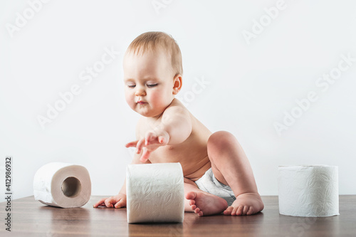 Funny baby and toilet paper on white background. Toddler ripping up toilet paper. potty training