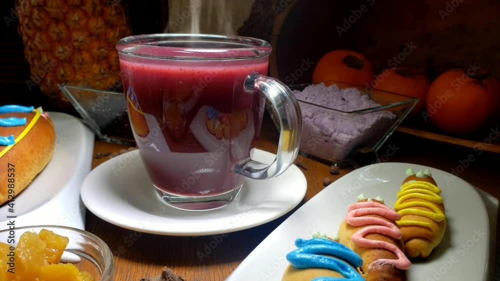 Colada morada, tradicional bebida hecho de mortiños y otras finas hierbas aromáticas. A un lado las tradicionales guaguas de pan