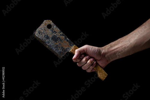 Old kitchen hatchet on a black background. A man's hand holds a kitchen hatchet. Kitchen tool