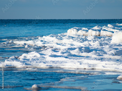 In the winter, stones are icy on the sea shore. Icicles hung from large pieces of ice