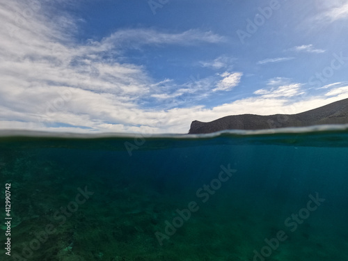 Split underwater photo of tropical exotic Caribbean emerald calm sea rocky bay