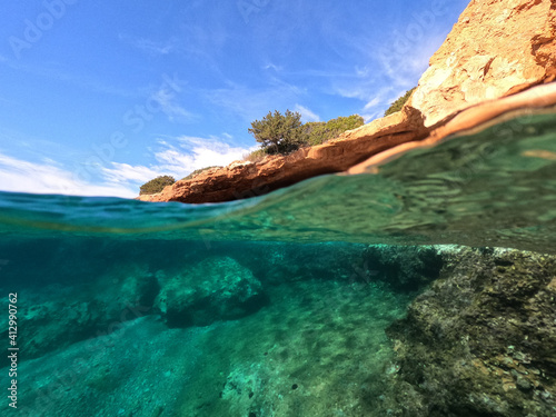 Split underwater photo of tropical exotic Caribbean emerald calm sea rocky bay