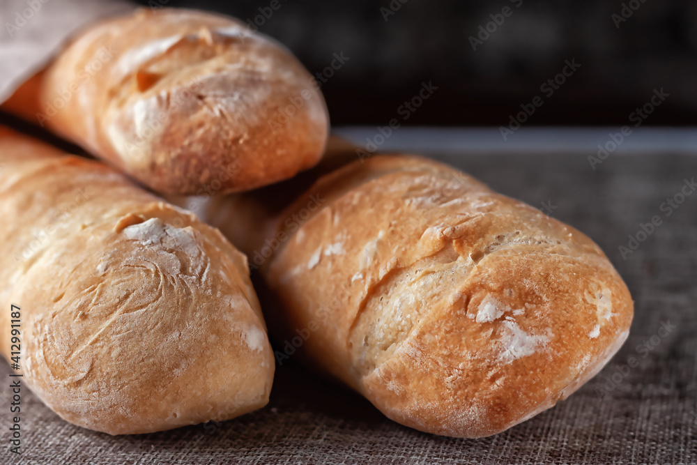 French baguettes on a table covered with cloth. Selective focus.